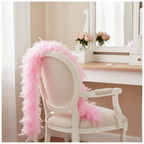 Soft baby pink feather boa draped over a white vintage vanity chair in an elegant feminine dressing room, natural window light