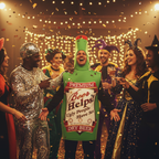 Man wearing green beer bottle fancy dress costume laughing at a party with friends in warm golden lighting