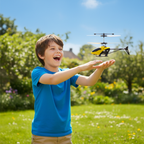 Boy flying mini RC helicopter in garden using hand sensor control - lifestyle image