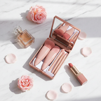 Flat lay of portable beige makeup brush set with mirror open on marble surface with beauty accessories