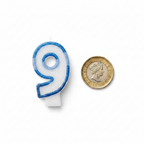 Blue glitter number 9 birthday candle flat lay beside a 1 pound coin showing product scale, white background overhead shot