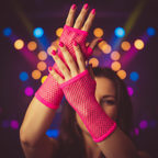 Woman's hands wearing neon pink fingerless fishnet net gloves with all fingers bare and exposed, confidently posed at an 80s themed party with neon lights in soft bokeh background