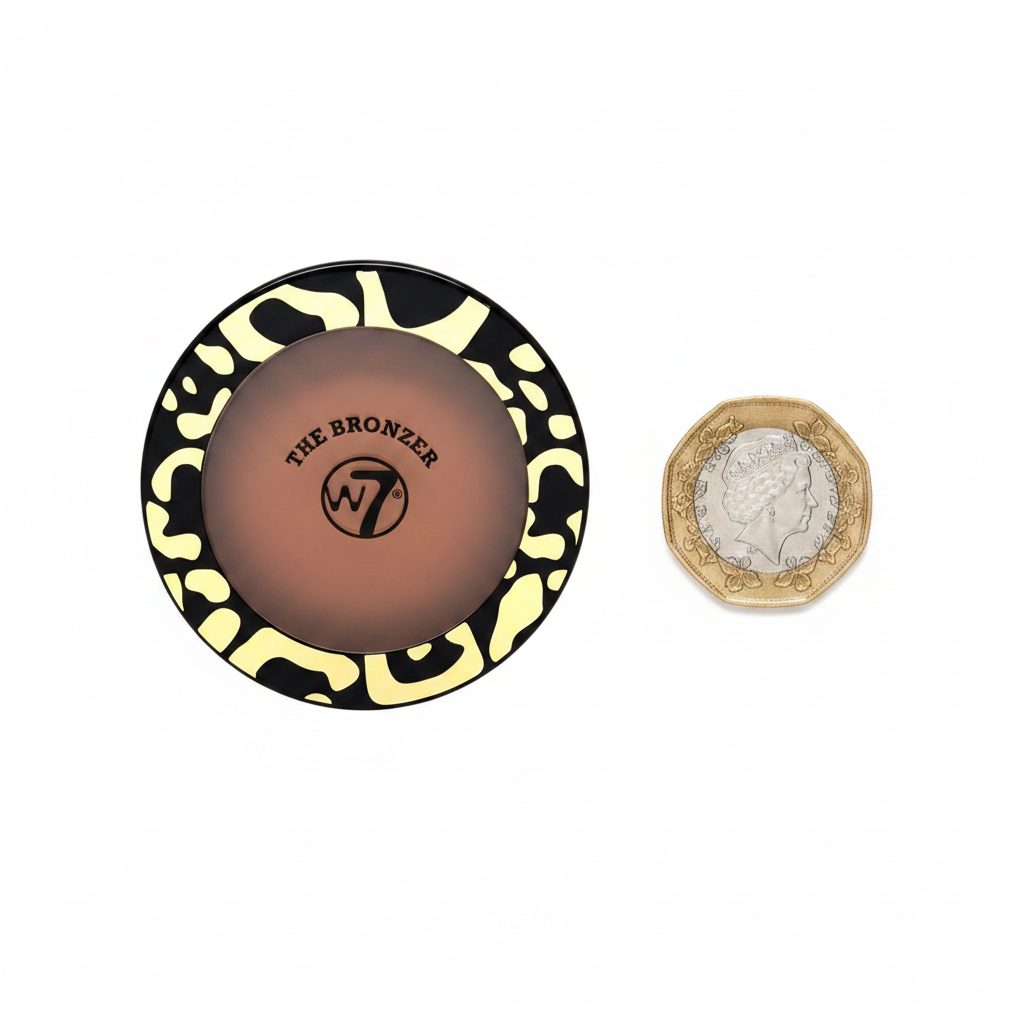 W7 The Bronzer Matte Bronzing Powder Compact flat lay beside £1 coin for size reference, white background with soft overhead lighting