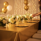 Gold party table cover styled on a glamorous birthday banquet table with champagne and flowers