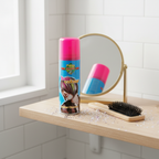 Party Success fluorescent pink hair colour spray on a dressing table with hairbrush, glitter and mirror in natural window light