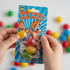 Child's hand picking individually wrapped hard boiled sweet from Funnyman Supersonic Sour Sweets blue blister card
