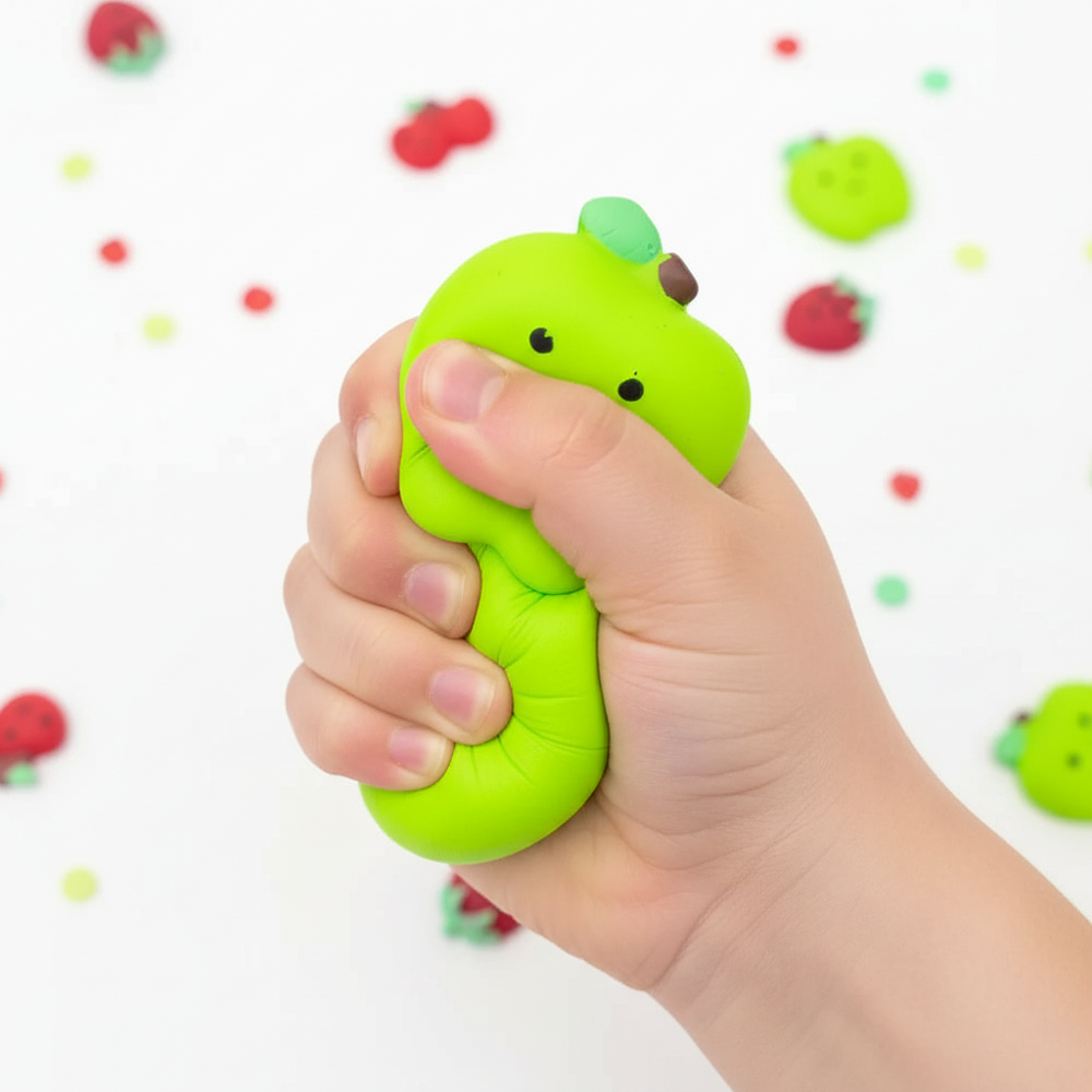 Close up of child squeezing fruit shaped squishy toy showing texture