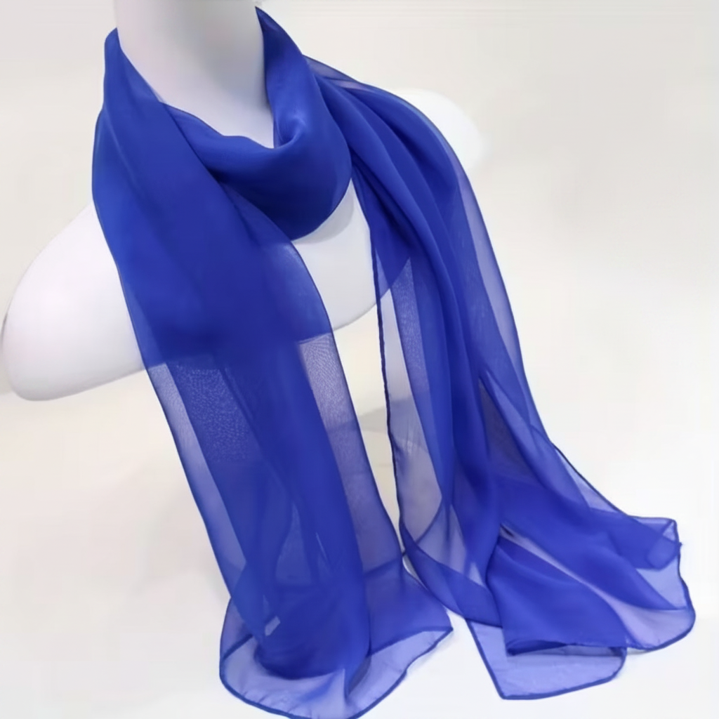 Women's long lightweight solid color thin blue chiffon scarf elegantly draped on a clean white background