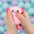 Close-up of child's hands squeezing a Smooshy Lotl axolotl toy showing soft squishy texture and cute face detail