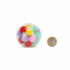 Squishy pom pom ball 6.5cm shown beside a British pound coin to demonstrate size, flat lay on white background