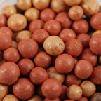 Extreme macro close-up of Body Collection Bronzing Pearls showing terracotta, golden-sand and espresso shimmer spheres with pearlescent finish