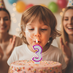 Young child blowing out pink glitter number 3 birthday candle on a cake, candid joyful moment with warm bokeh background