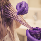 Person applying La Riche Directions Violet hair dye to hair strands, candid application moment with bokeh background
