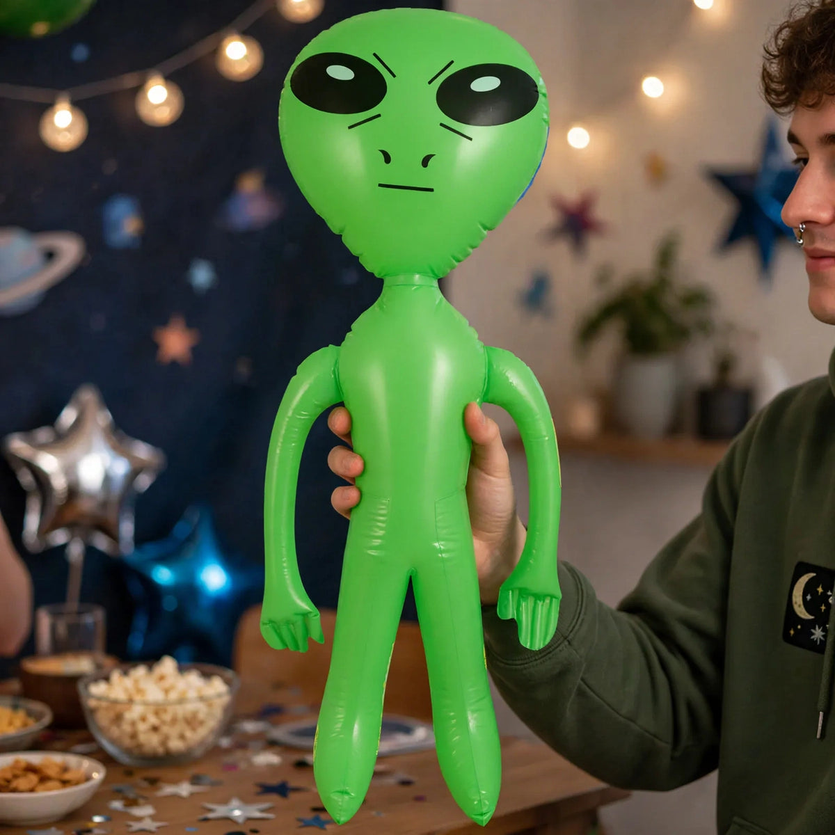 Inflatable green alien displayed at a party with sci-fi and space theme