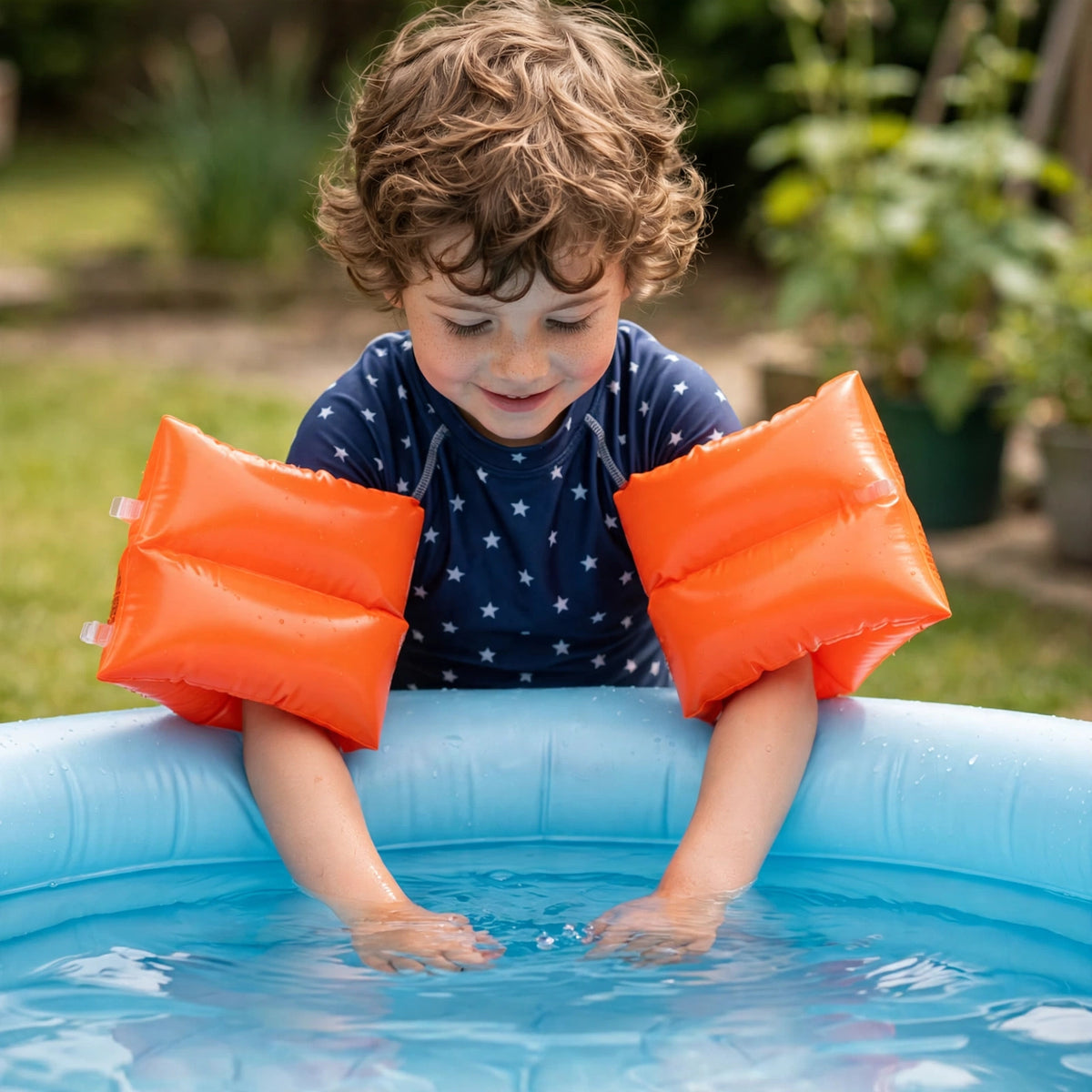 Child wearing bright orange Intex inflatable swimming arm bands in a pool setting