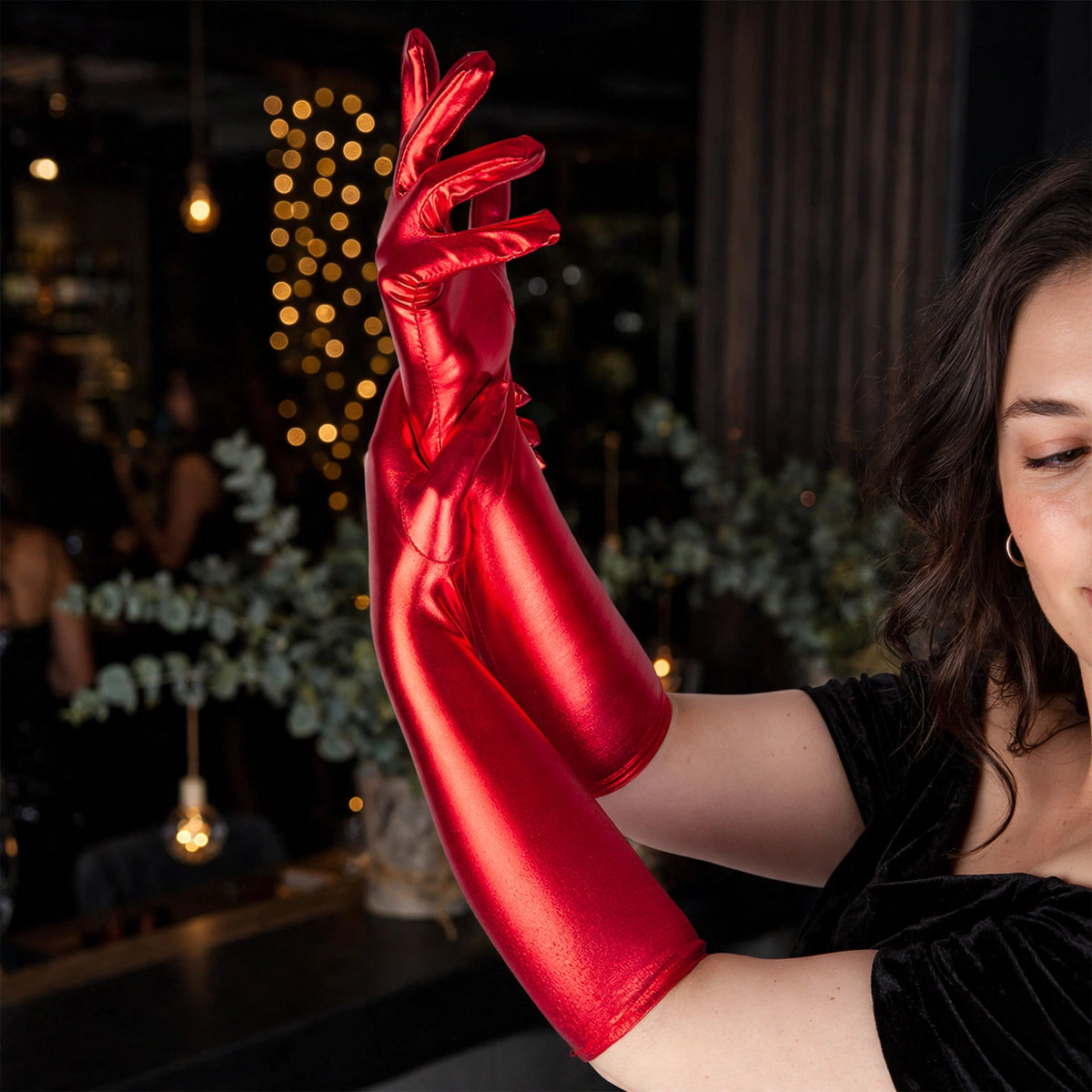 Ladies long metallic red gloves worn as a striking accessory for parties or fancy dress