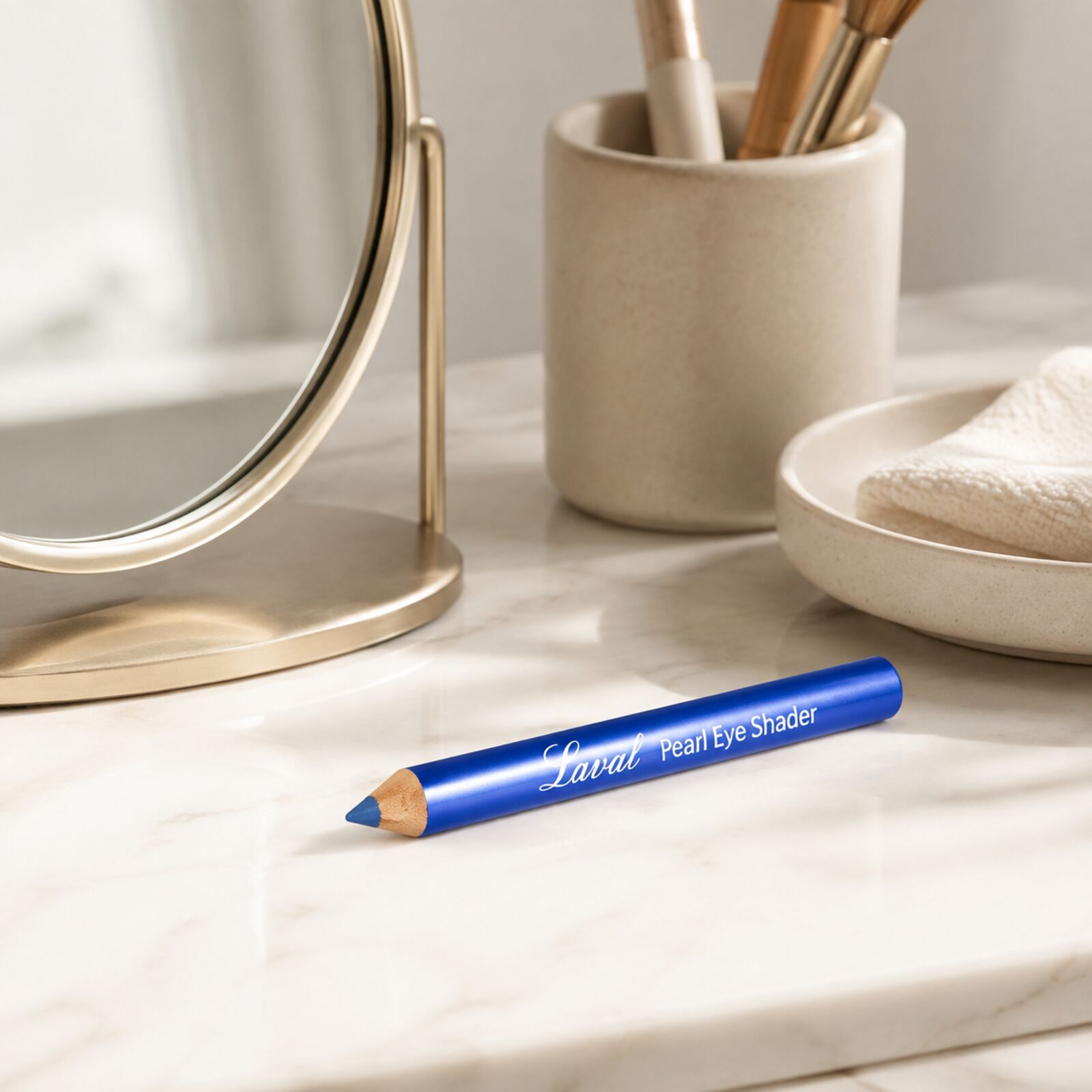 Laval Ocean Blue eyeshadow pencil displayed on a neutral dressing table beside a mirror