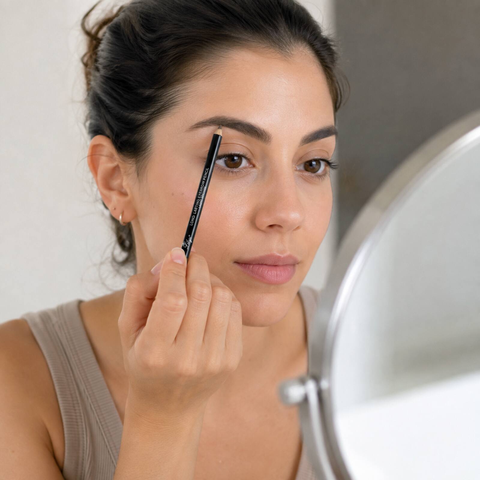 Adult applying the Lilyz Light Brown pencil with light controlled eyebrow strokes