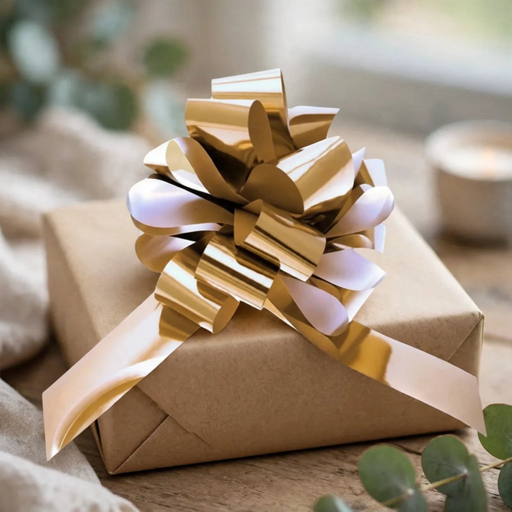 Metallic gold pull bow decorating a wrapped gift box