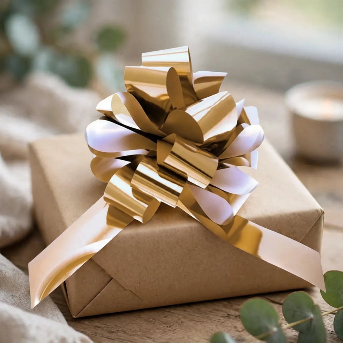 Metallic gold pull bow decorating a wrapped gift box