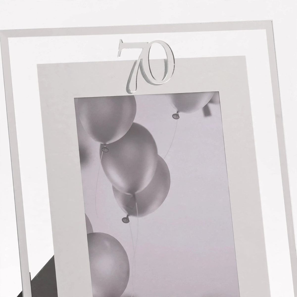 Close-up view of silver photo frame with 70th birthday inscription