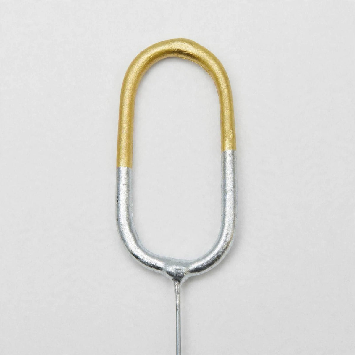 Close-up view of number 0 birthday sparkler showing gold and silver finish