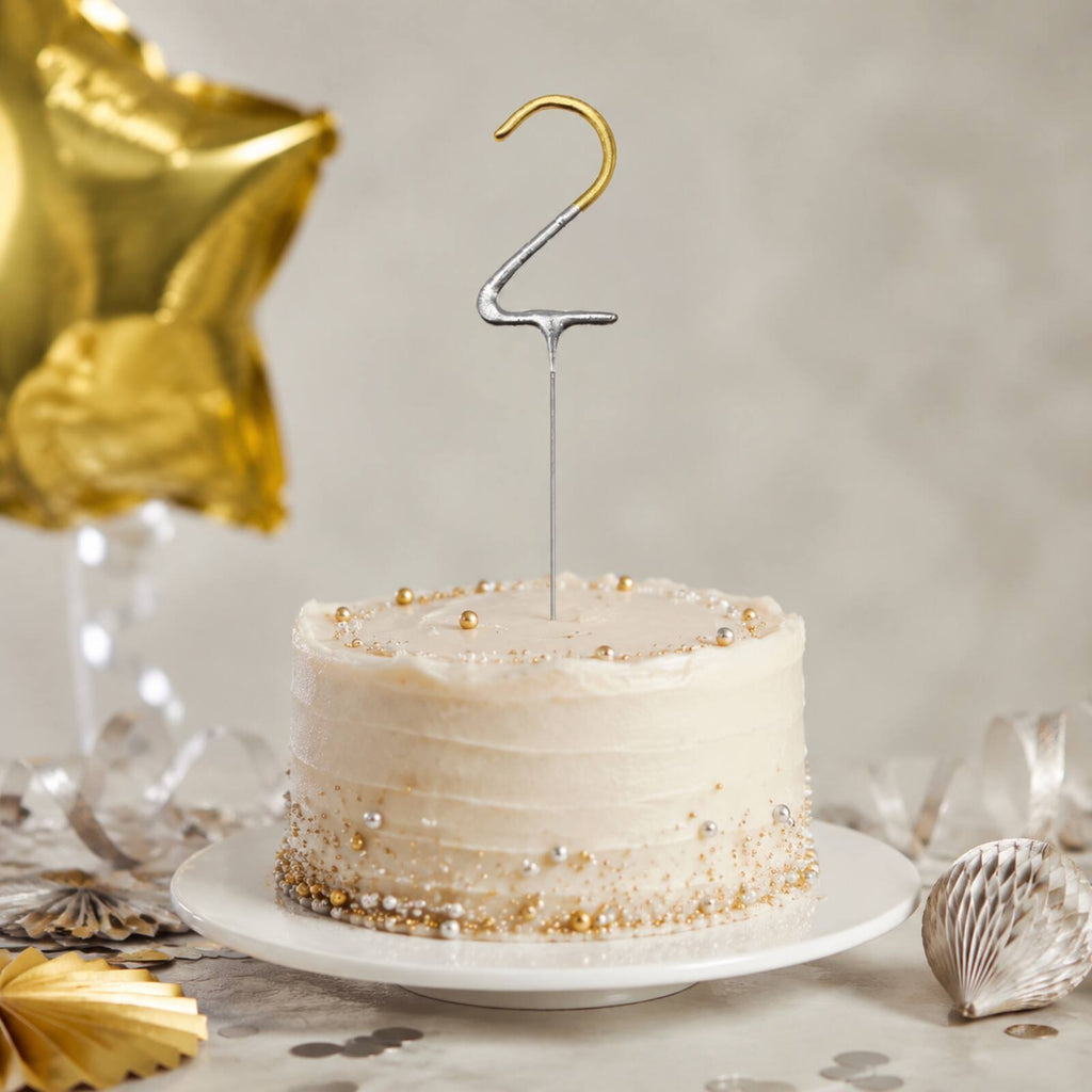 Unlit gold number 2 birthday sparkler in a silver and gold party display