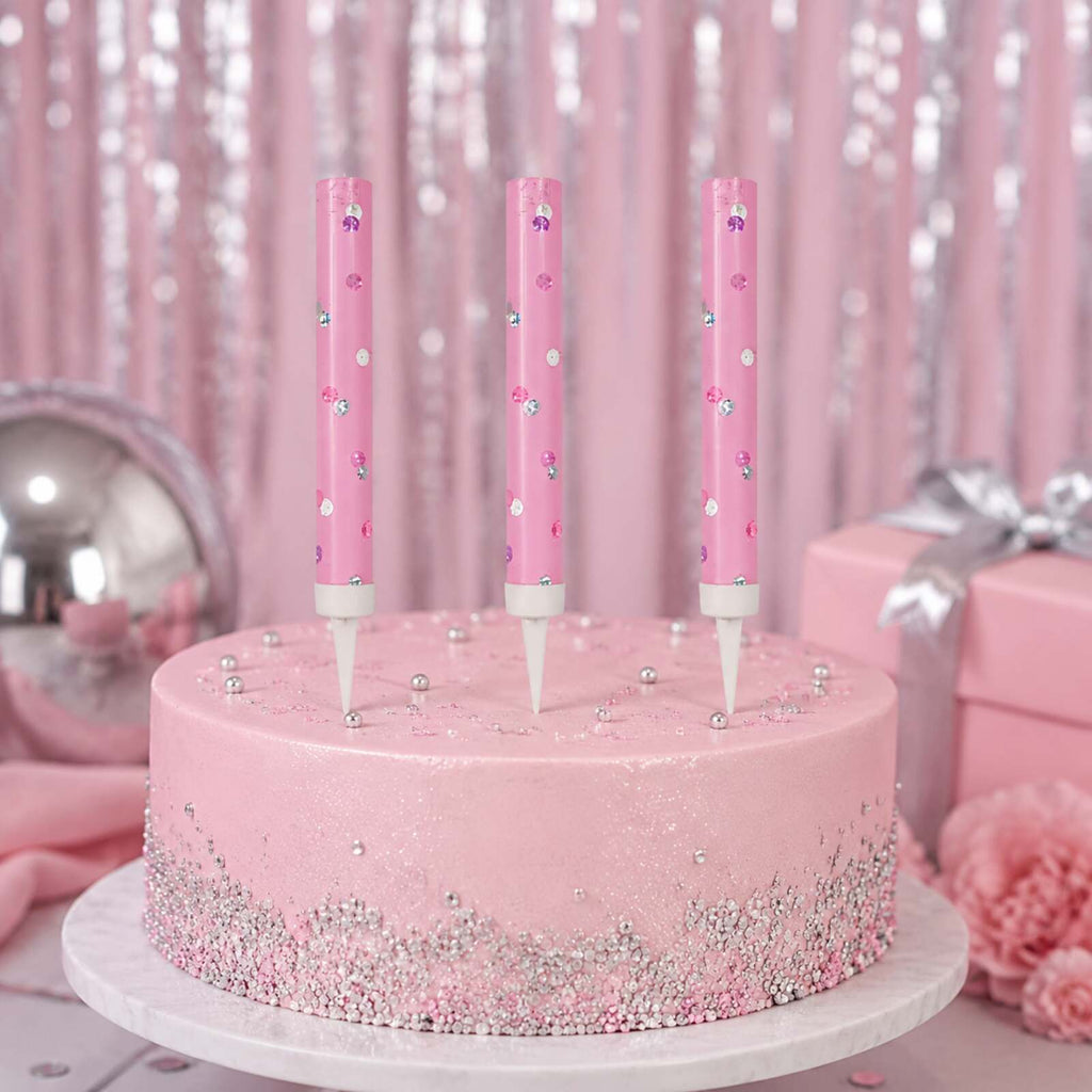 Three unlit pink glitz ice fountains displayed on a pink celebration cake