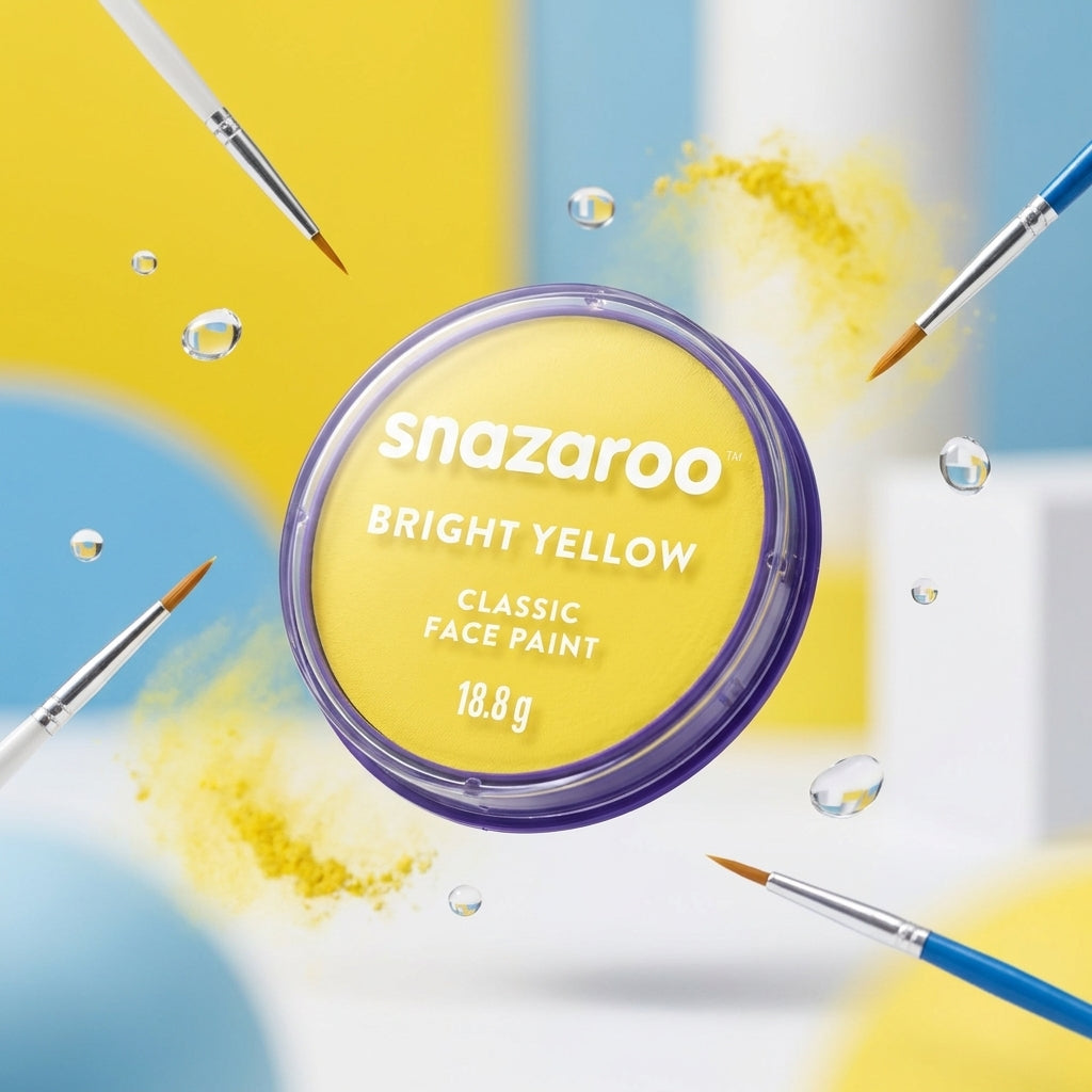 A round tin of Snazaroo Bright Yellow Classic Face Paint floating in a stylized studio scene with paintbrushes, paint splatters, and water droplets around it.