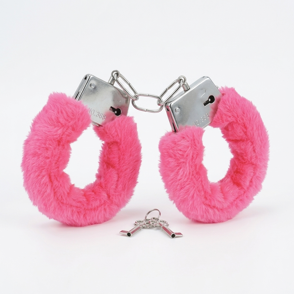 Bright pink faux fur handcuffs with silver metal lock hardware and a small matching key, photographed on a clean white background.