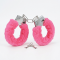 Bright pink faux fur handcuffs with silver metal lock hardware and a small matching key, photographed on a clean white background.