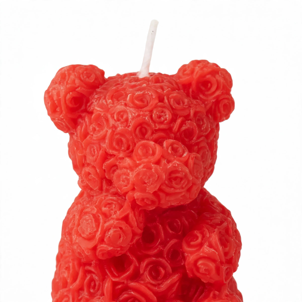 Close-up view of scented rose bear candle with miniature rose petals