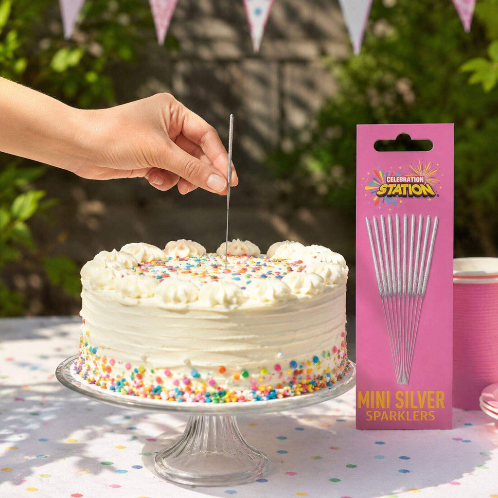 Adult placing an unlit mini silver sparkler into a birthday cake outdoors