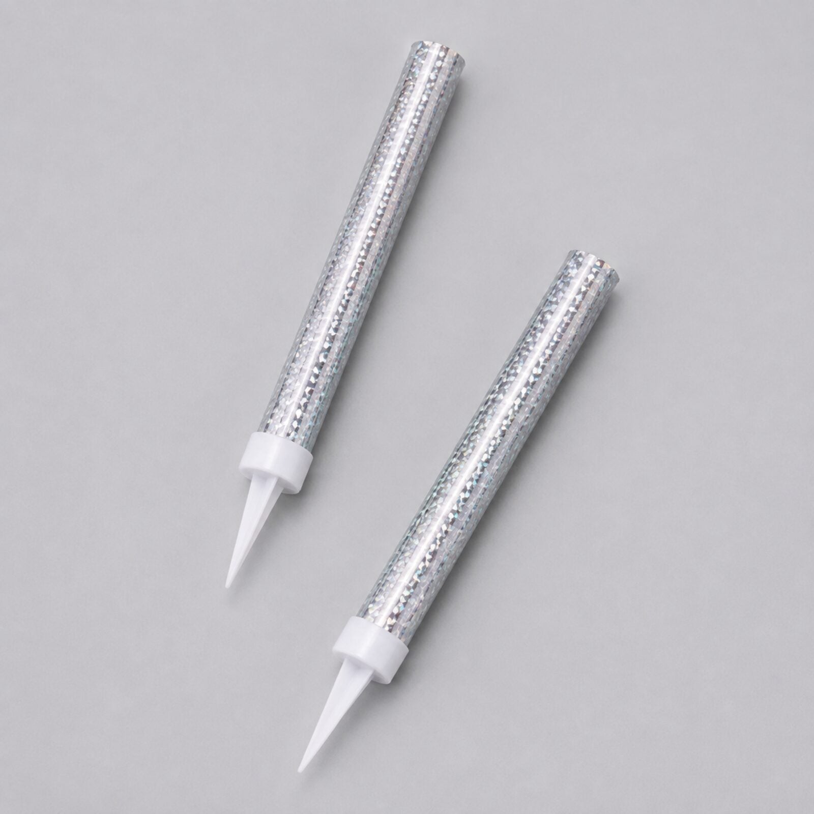 Two silver prismatic ice fountain cake decorations showing foil finish and white spikes