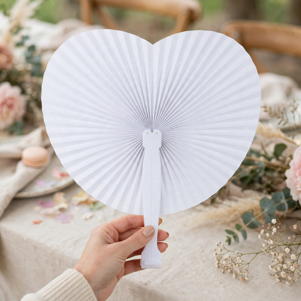White heart-shaped paper fan displayed as a table decoration at a wedding or party